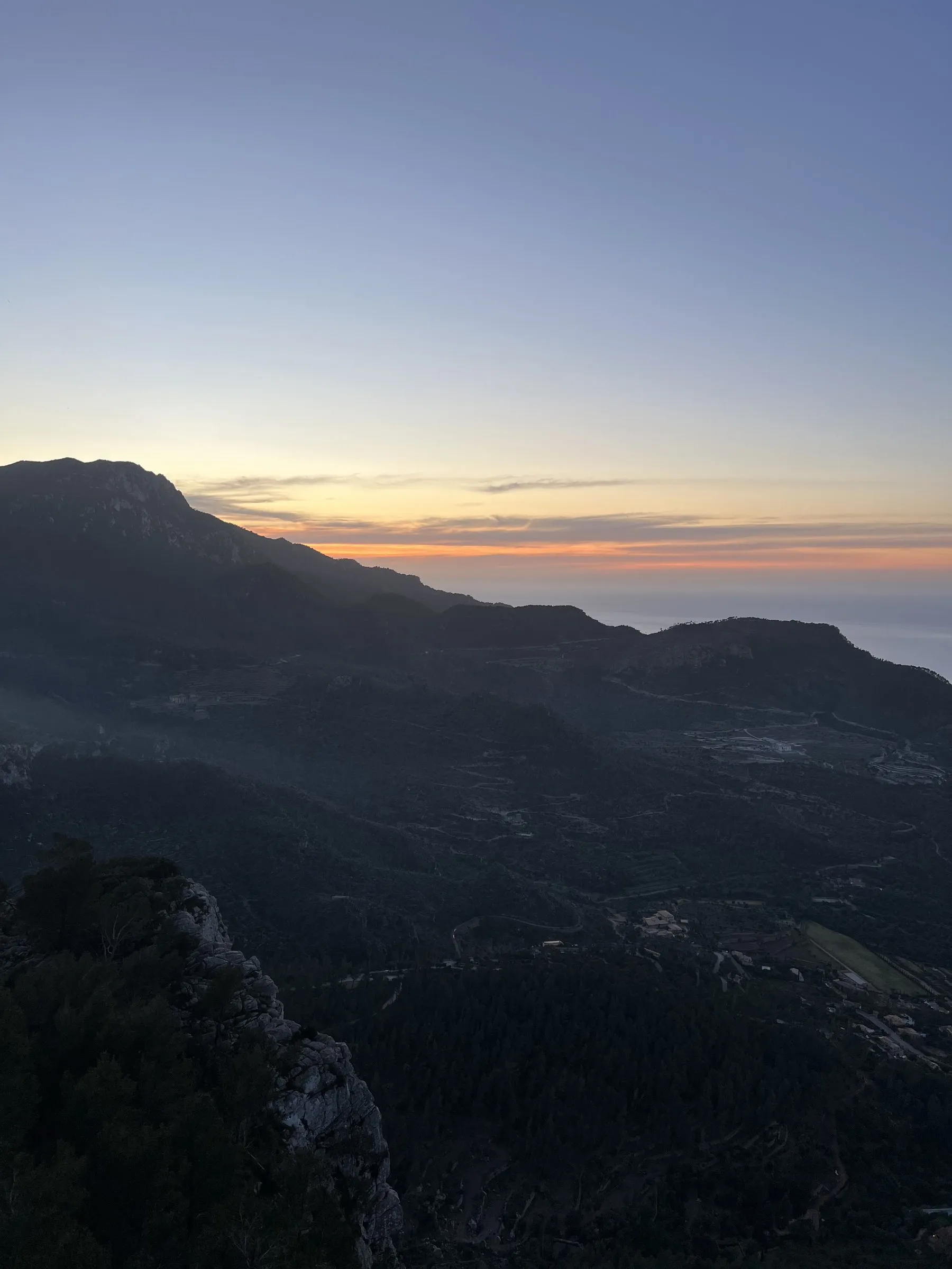 La silueta de la sierra recortada contra la última franja naranja del horizonte sobre el mar.
