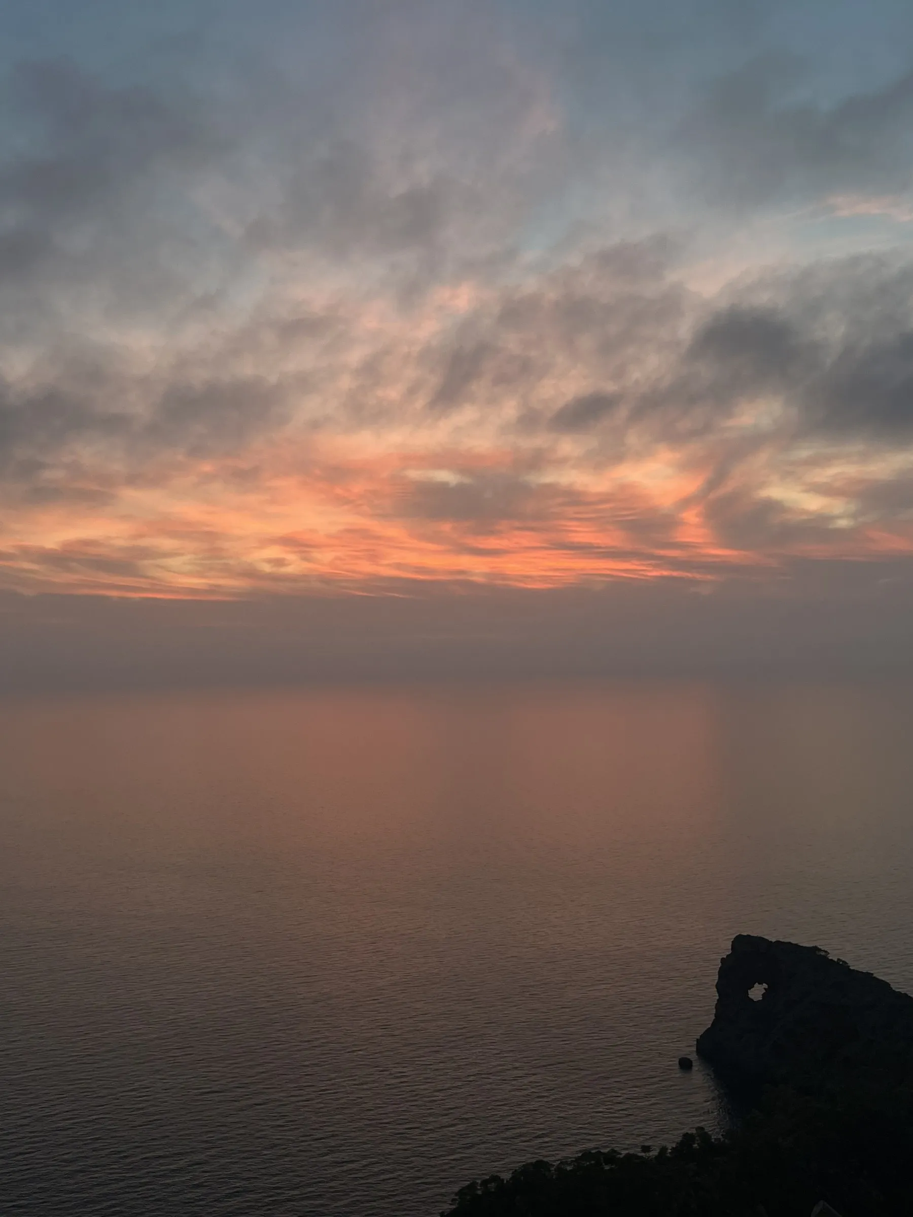 Nubes encendidas de naranja sobre el mar en calma al atardecer en el Cap de ses Salines.